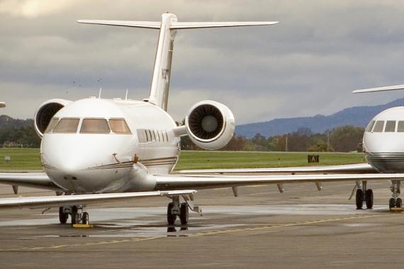 Two midsize planes sit on a tarmac