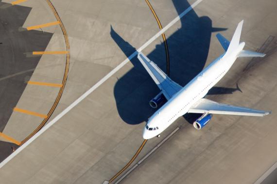 Overhead view of a large white airplane on an airport runway
