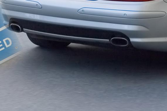 A close-up of the back of a silver car and its exhaust pipes