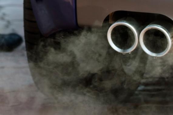 Close-up view of a car's exhaust pipes releasing carbon monoxide