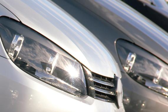Close-up of the front of a row of cars, prominently featuring their headlights