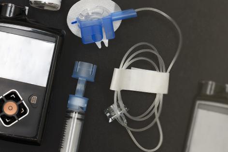 Overhead view of the components of an insulin pump and infusion set